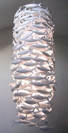 10 cm hosszú fehér műanyag halak egymáshoz űzve egy 70cm magas30cm átmérőjű henger köré